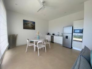 uma cozinha com uma mesa e cadeiras e um frigorífico em CASA AYLA B - charming 2BR ocean view condo in Flamingo em Playa Flamingo