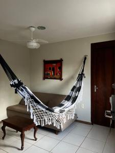 a hammock hanging on the wall in a living room at Pousada Flor de Maraca in Porto De Galinhas