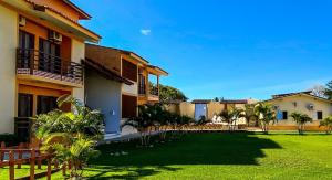 a courtyard of a house with a green lawn at Residencial Malibu in Porto Seguro