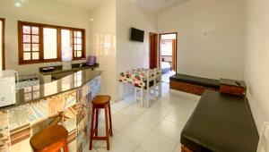 a kitchen with a counter and a bar with a stool at Residencial Malibu in Porto Seguro