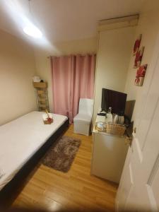 a bedroom with a bed and a desk with a television at Double size and Single room in Barking in Barking +25 photos