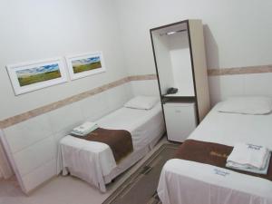 a room with two beds and a mirror at Ribeirao Hotel in Sousa