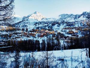 a town in the snow with mountains in the background at Cosy/familiale/Front de neige in Isola 2000