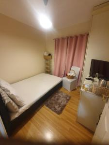 a bedroom with a bed and a pink curtain at Double size and Single room in Barking in Barking