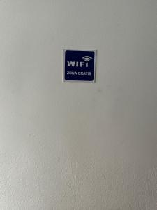a sign on the side of a white wall at Fast Single Rooms in Madrid