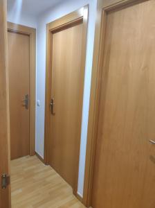 um corredor vazio com duas portas de madeira num quarto em Fast Single Rooms em Madrid