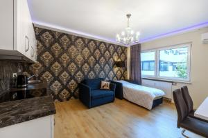 リュッセルスハイムにあるPMC Business Apartmentsのベッドルーム1室(ベッド1台、青い椅子付)