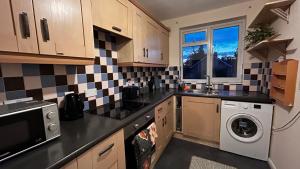 a kitchen with a washer and dryer in it at Cozy 2 Bedroom Apartment close to Town Centre in Woking