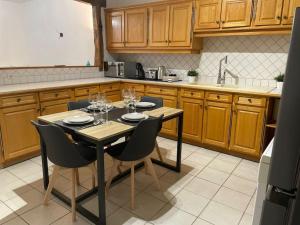 a kitchen with a table and chairs with wine glasses on it at Grande maison : Près de Paris/Orly in Villeneuve-le-Roi