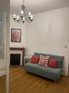 a living room with a blue couch with red pillows at Grande maison : Près de Paris/Orly in Villeneuve-le-Roi