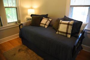 a couch with pillows on it in a room at Cozy Home in Milwaukee Near Festivals and Brewers in Milwaukee