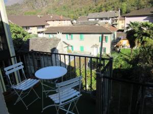 a balcony with two chairs and a table with a view at Maisonette in Biasca