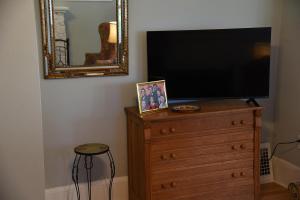 a television on top of a dresser with a mirror at Cozy Home in Milwaukee Near Festivals and Brewers in Milwaukee