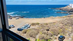Blick auf den Strand mit auf dem Sand geparkt in der Unterkunft El Apartamento de Margot in Las Toscas