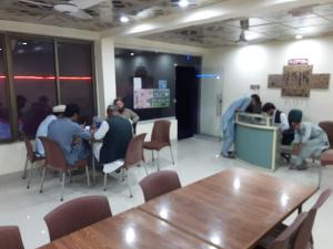 a group of people sitting around a table in a room at Bab e Gilgit Inn in Gilgit