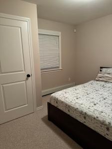 ein Schlafzimmer mit einem Bett und einer weißen Tür in der Unterkunft Nitomik Private Suite in Halifax