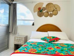 聖何塞皇冠大的住宿－FLAT 13º andar COM VISTA PARA MARagogi，一间卧室配有一张带五颜六色的被子的床和窗户