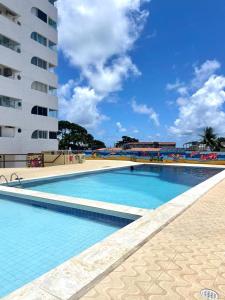 uma grande piscina ao lado de um edifício alto em FLAT 13º andar COM VISTA PARA MARagogi em São José da Coroa Grande