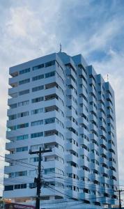 um grande edifício azul com janelas em cima em FLAT 13º andar COM VISTA PARA MARagogi em São José da Coroa Grande