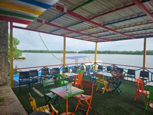 Baru sunset في بارو: مجموعة طاولات وكراسي على قارب على الماء