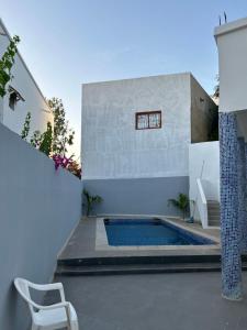 a house with a swimming pool in a courtyard at Villa Kayus - Toubab Dialaw in Rufisque