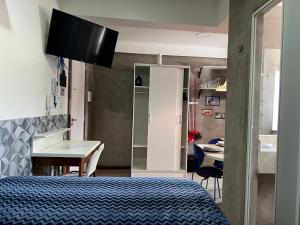 a bedroom with a bed and a desk and a kitchen at STUDIO 203 | WIFI 600MB | RESIDENCIAL JC, um lugar para ficar. in Belém