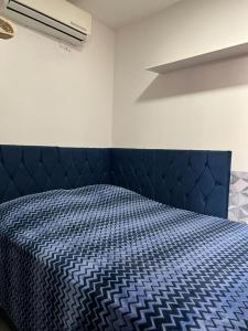 Ce lit se trouve dans un dortoir doté d'une couette bleue. dans l'établissement STUDIO 203 | WIFI 600MB | RESIDENCIAL JC, um lugar para ficar., à Belém