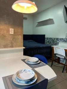 una habitación con una mesa con platos. en STUDIO 203 | WIFI 600MB | RESIDENCIAL JC, um lugar para ficar., en Belém