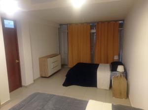 1 dormitorio con 1 cama y vestidor en TAWA 2, en Huancayo