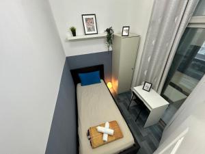 Habitación pequeña con cama y mesa en Partition Room 3 Mins to Mashreq Metro en Dubái