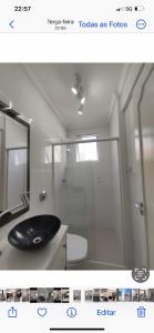 La salle de bains est pourvue d'un lavabo noir et d'une douche. dans l'établissement AP em CONDOMINIO BEIRA MAR com GARAGEM, WIFI e TV A a CABO, à Balneário Camboriú