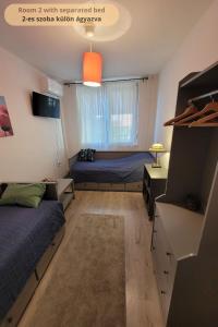 sypialnia z 2 łóżkami i pomarańczowym światłem w obiekcie Tulip Home Guest House w mieście Vác