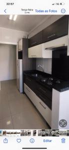 - une cuisine avec des armoires en noir et blanc et un réfrigérateur dans l'établissement AP em CONDOMINIO BEIRA MAR com GARAGEM, WIFI e TV A a CABO, à Balneário Camboriú