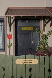 a front door of a house with a sign on it at Tulip Home Guest House in Vác