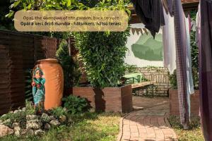a sign in a garden with a woman painted on a vase at Tulip Home Guest House in Vác