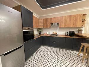 uma cozinha com um frigorífico de aço inoxidável e armários de madeira em Grace Apartments em Boryspil