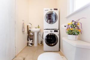 a washing machine in a white bathroom with a sink at Queen Beds, Fast WiFi, Free Parking, Central A/C, TV's in New Haven