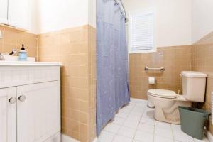 a bathroom with a toilet and a blue shower curtain at Queen Beds, Fast WiFi, Free Parking, Central A/C, TV's in New Haven
