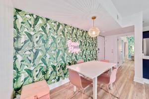 a dining room with a white table and pink chairs at Beach Please condo 2 bedroom 2 bath sleeps 6 in Gulf Shores