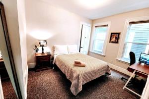 a bedroom with a bed and a desk and windows at Queen Beds, Fast WiFi, Free Parking, Central A/C, TV's in New Haven