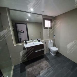 La salle de bains est pourvue d'un lavabo, de toilettes et d'un miroir. dans l'établissement Nostalgic Nirvana Villa Taghazout Bay ocean & mountain view, à Taghazout