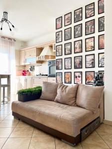 a couch in a living room with a wall of pictures at 4th FLOOR ROOMS private rooms in apartment in Turin