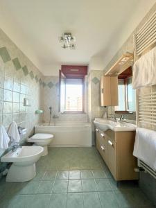 a bathroom with two sinks and a toilet and a tub at 4th FLOOR ROOMS private rooms in apartment in Turin