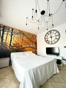 a bedroom with a large bed and a clock on the wall at 4th FLOOR ROOMS private rooms in apartment in Turin