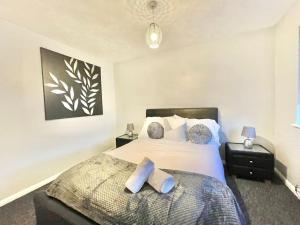 a bedroom with a large bed with two pillows at Ashford 3 Bedroom house with parking central area, private garden in Kent