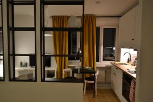 uma cozinha com cortinas amarelas e uma mesa num quarto em Valmiera Studio apartment em Valmiera