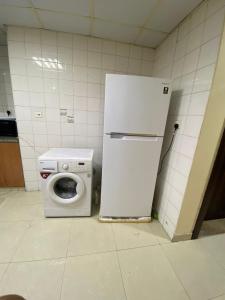 a white refrigerator and a washing machine in a kitchen at Prime Partition Room in Al Barsha 1 Near Metro in Dubai