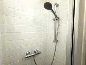a shower with a shower head in a bathroom at Messe-Apartment für 5 Gäste mit Balkon und Lift in Hannover