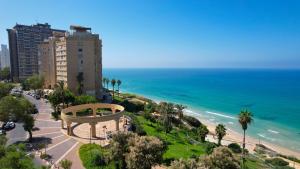 a view of a beach and a building and the ocean at Dana in Netanya