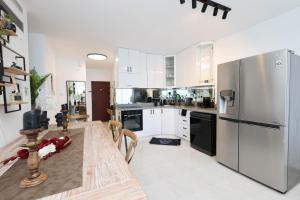a kitchen with white cabinets and stainless steel appliances at Dana in Netanya